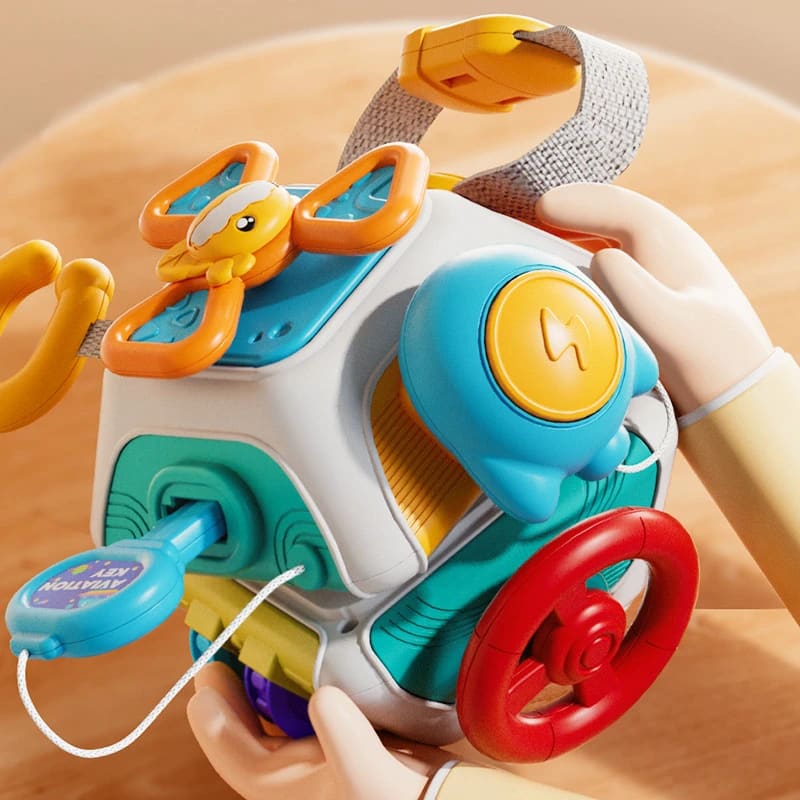 Hands playing with the polyhedron busy board - steering wheel, rattle and wrist strap